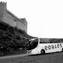 Imagen en blanco y negro de un autobús de la flota llegando a una zona amurallada