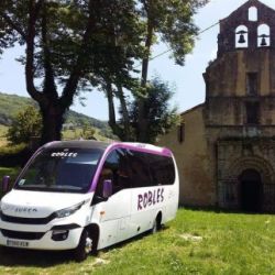Mini bus parado junto a la puerta de entrada de una ermita romana